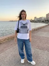 Remera oversize de algodón peinado, color blanco, con estampado gráfico frontal de un chaleco táctico en escala de grises y la palabra VINNARE en el centro.