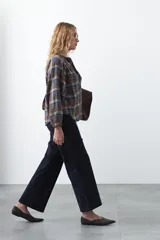 Pantalón de pana color marrón chocolate, de corte recto con bolsillos laterales y cierre frontal.