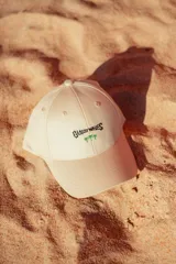 Gorra color crudo con bordado frontal de la frase "Glossy Waves" y dos palmeras.