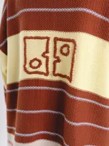 Cardigan tejido de punto jacquard en tonos bordó y rojo con rayas, de corte oversize, cuello redondo y cierre frontal con botones carey. Presenta detalles bordados en contraste y monograma en la espalda.