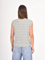 Remera sin mangas de corte holgado, con cuello redondo y diseño de rayas horizontales finas en color negro sobre fondo blanco.