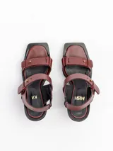 Sandalias negras de cuero vacuno con tiras, detalles de gemelos en bronce, taco de madera y plataforma de EVA.