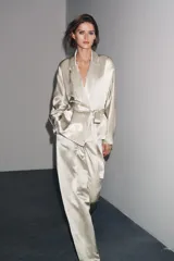 Blazer color plateado confeccionada en hilatura con mezcla de viscosa y lino. Tiene cuello solapa de muescas, manga larga y cinturón en mismo tejido ajustable con lazadas.