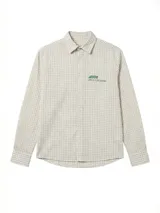 Camisa de lino con diseño de cuadrillé en tonos blanco y beige, de manga larga y cuello clásico. Presenta una pequeña estampa en el pecho y una estampa en la espalda, con un calce holgado y relajado.