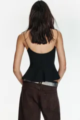 Top negro de escote redondo con tirantes muy finos y bajo acabado en peplum.