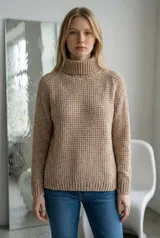 Sweater de cuello alto tipo polera, confeccionado en tejido de chenille con textura de relieve tipo waffle. Presenta mangas largas con puños acanalados y ruedo también acanalado.