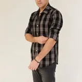 Camisa de manga larga a cuadros grises y negros, con cuello clásico y cierre con botones.