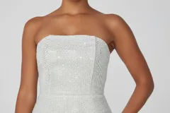 Vestido corto strapless cubierto de lentejuelas plateadas brillantes, con ajuste entallado y diseño minimalista.