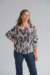 Sweater de punto con diseño animal print en tonos marrones, grises y detalles metalizados dorados. Presenta un corte holgado, cuello redondo y mangas largas con puños acanalados.