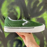 Championes Vans modelo Knu Slip On, color verde oscuro, con diseño de perfil bajo sin cordones, confeccionados en gamuza con suela de goma blanca vulcanizada.