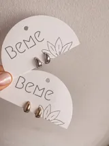 Par de aros pequeños tipo argolla, uno plateado y otro dorado.