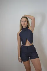 Top de jean azul oscuro, corte crop, con cuello halter y espalda descubierta.