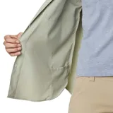 Camisa de manga larga Columbia, color verde claro, con cuello clásico, cierre frontal de botones y dos bolsillos en el pecho. Presenta un diseño técnico con ventilación, ideal para actividades al aire libre.