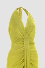 Vestido largo de fiesta color amarillo brillante, con escote halter, drapeado frontal y espalda descubierta.