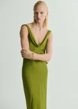 Vestido largo de fiesta en tejido satinado color verde, con escote drapeado, tirantes anchos y espalda también drapeada. Presenta un diseño entallado con cierre de cremallera lateral y una sutil textura en la tela.