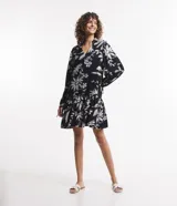 Vestido corto de viscosa con estampado floral en blanco y negro, escote en V, mangas largas con lazo en los puños y volados en el ruedo.