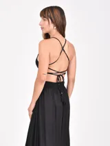 Vestido largo negro con diseño cut-out en la cintura y detalle de abertura circular en el pecho con cordón ajustable. Presenta breteles finos y falda amplia con tajo frontal.