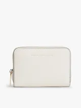Billetera compacta Tommy Hilfiger de color blanco con acabado texturizado y cierre de cremallera perimetral. Cuenta con logo metálico dorado en relieve en la parte frontal.