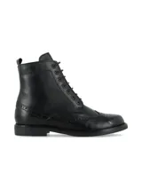 Bota tipo borcego de cuero napa color negro, con diseño de inspiración Oxford que presenta detalles de perforaciones decorativas (brogue) en la puntera y laterales. Cuenta con cierre de cordones y suela de goma TR.