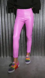 Pantalón largo de ecocuero color lila, con tiro alto, calce ajustado y botamanga irregular.