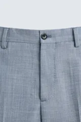 Pantalón de vestir corte slim fit, confeccionado en tejido con lana, con bolsillos frontales y traseros de doble vivo con botón.