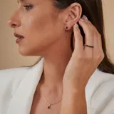Collar de oro 18k con cadena fina de eslabones y dije ovalado central que presenta un zafiro azul rodeado por pequeños brillantes.