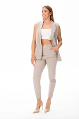 Pantalón de vestir color beige, con corte recto, bolsillos laterales y cinturón con hebilla metálica.