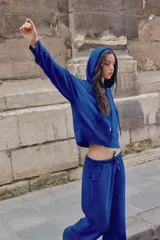 Pantalón flare de tiro medio, color azul, confeccionado en tejido de punto elástico. Cuenta con cintura elástica ajustable con cordón, bolsillos delanteros y corte amplio en las piernas.