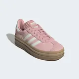 Championes Adidas Gazelle Bold de mujer, color rosa palo con tres franjas laterales blancas y logo 'GAZELLE' en dorado. Cuentan con una suela de plataforma gruesa color caramelo y detalles en blanco en el talón y la lengüeta.