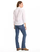 Camisa blanca de algodón con cuello clásico, cierre frontal con botones nacarados, mangas tres cuartos con puños anchos rebatibles y corte entallado con pinzas.