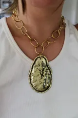 Collar dorado con cadena de eslabones grandes y dije irregular martillado.