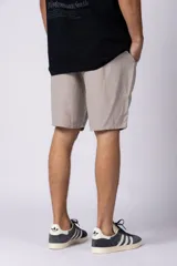 Bermuda de lino color beige, de corte recto y diseño relajado, con cintura elástica y bolsillos laterales.