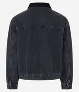 Campera trucker de corte boxy en denim color gris lavado. Presenta cuello de terciopelo negro, cierre frontal con botones metálicos y dos bolsillos frontales con solapa.