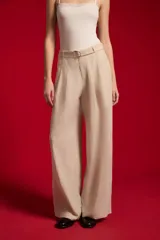 Pantalón ancho de lyocell color beige con pinzas en la parte delantera, tiro alto y un cinturón delgado con hebilla redonda metálica.