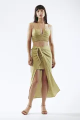 Crop top de lino color verde oliva, con escote halter y detalle de fruncido en la parte inferior.