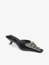 Sandalia mule negra de cuero sintético con punta cuadrada, taco kitten heel y apliques de esferas metálicas plateadas.