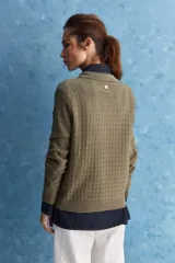 Sweater de punto color verde militar, con cuello polo y cierre frontal de botones, de manga larga con puños elastizados y diseño texturizado con relieve geométrico.
