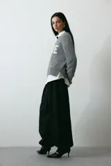 Buzo de punto gris melange con diseño jacquard y la palabra 'ADORE' en blanco en el frente, cuello redondo y hombros caídos.