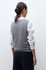 Chaleco de tejido de punto con escote en V y terminaciones acanaladas en cuello y sisas.