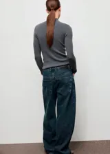 Jersey de punto fino color gris con cuello perkins, diseño entallado y manga larga.