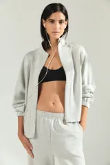 Campera deportiva de cuello alto con cierre frontal completo, mangas largas con puños elásticos y diseño holgado.