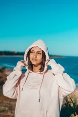 Hoodie de corte oversize color rosado, con capucha, mangas largas y estampa trasera con la inscripción "Glassy Waves Surf Company".