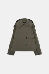 Trench corta verde militar con capucha, cuello solapa y manga larga con trabillas en los puños. Presenta bolsillos delanteros de vivo y cierre frontal cruzado con doble botonadura.