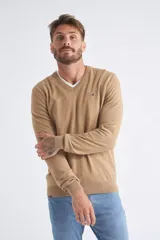 Sweater de tejido de punto color beige, con escote en V, mangas largas y puños y dobladillo acanalados. Presenta un pequeño logo bordado en el pecho.