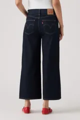 Jean de denim azul oscuro con corte wide leg y diseño cropped al tobillo, con tiro medio y costuras en contraste.