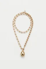 Collar largo dorado de doble tira, compuesto por una cadena de eslabones y una cadena de cuentas esféricas, con un dije colgante en forma de gota.