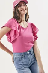 Remera fucsia de algodón peinado, con escote redondo, calce al cuerpo y mangas cortas amplias con detalles calados y vuelo.