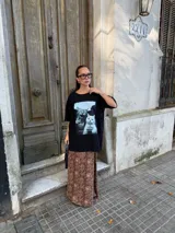 Conjunto compuesto por un remerón negro de algodón con estampa fotográfica frontal y una pollera midi de satén con estampado animal print de leopardo.