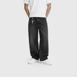Pantalón de jean estilo baggy, de corte holgado y tiro medio, en color negro con efecto lavado. Presenta diseño de cinco bolsillos y cierre frontal con botón y cremallera.