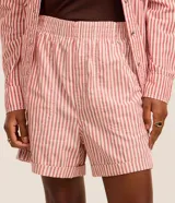 Bermuda runner Marfinno confeccionada en sarga de algodón con estampado de rayas verticales rojas y blancas, cintura elástica y bajo con vuelta.